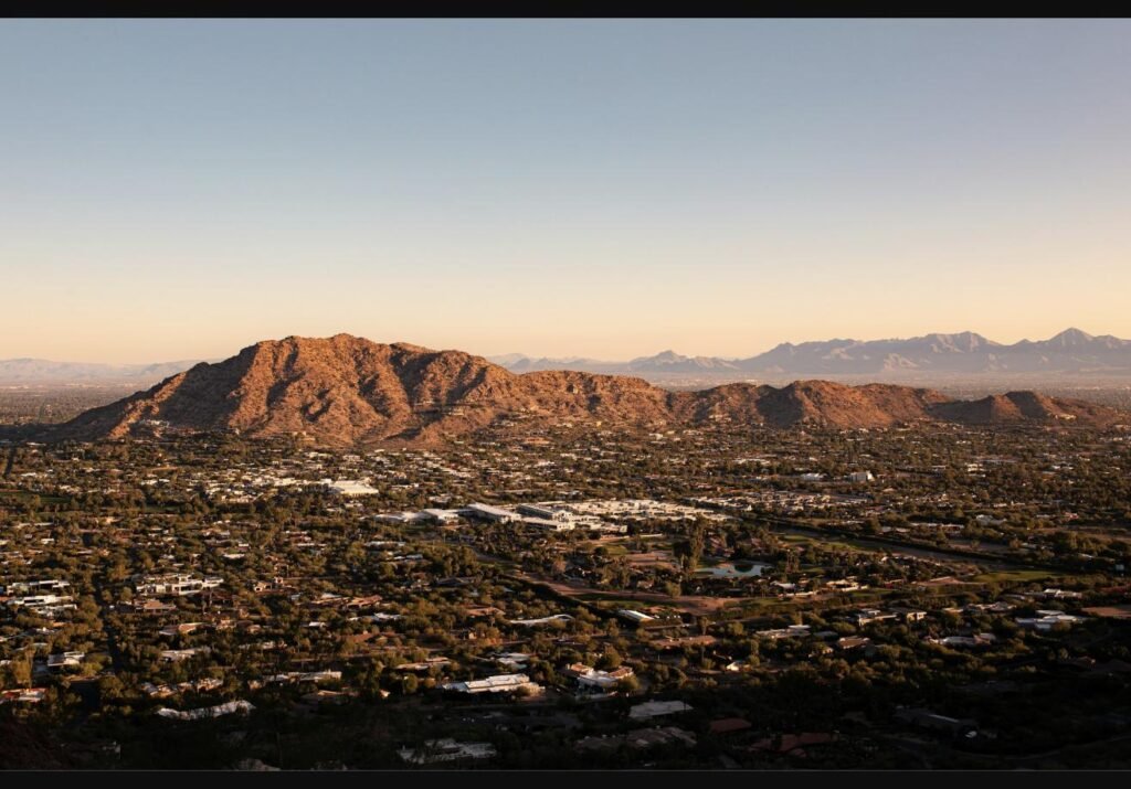Aerial view of a Phoenix-area neighborhood near the mountains at golden hour, representing the fall 2026 Phoenix housing market